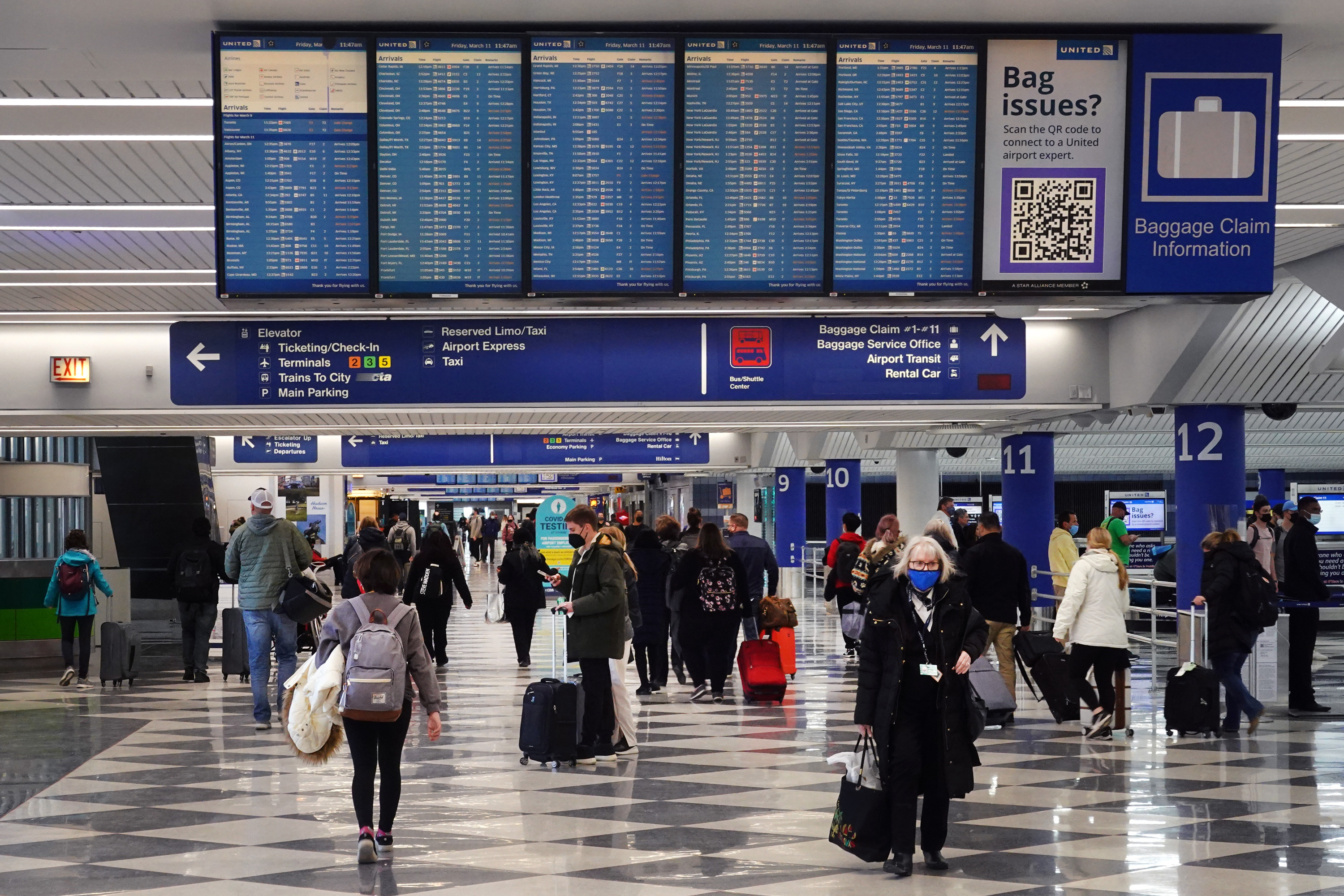CHICAGO, ILLINOIS – MARCH 11: Travelers collect their luggage at baggage claim after arriving at O’Hare International Airport on March 11, 2022 in Chicago, Illinois. The airport, which typically serves 8.2 million passengers a month, was nearly deserted at this time two years ago after the COVID-19 pandemic significantly reduced air travel. (Photo by Scott Olson/Getty Images)
